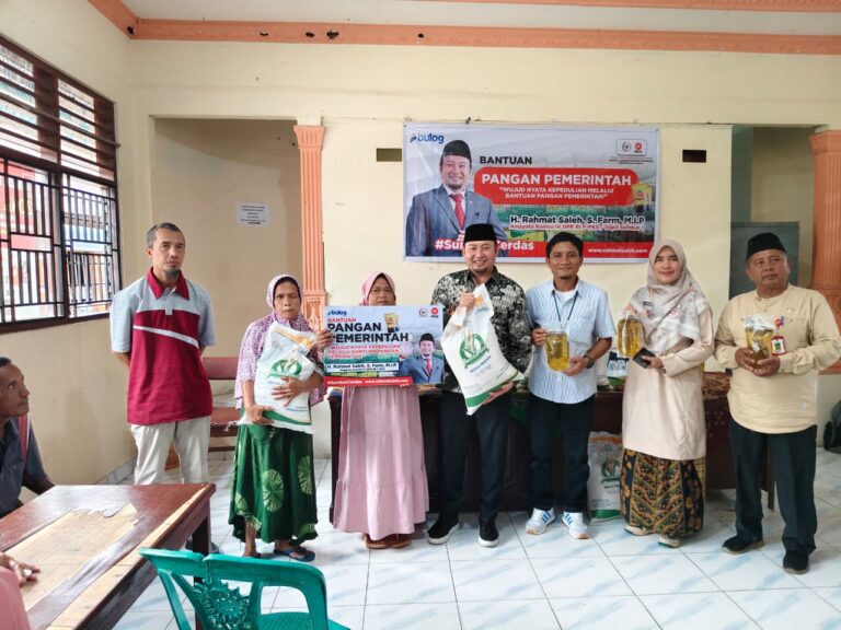 Rahmat Saleh menyerahkan bantuan beras kepada seorang warga Binuang, didampingi oleh beberapa tokoh masyarakat setempat.